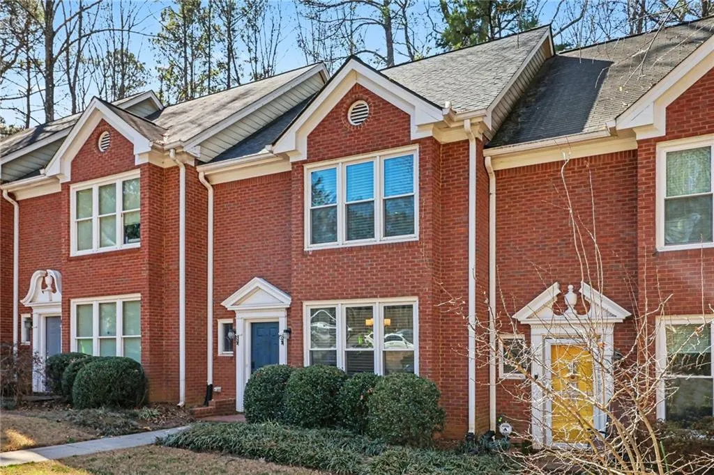View of front of house featuring brick siding and a shingled roof