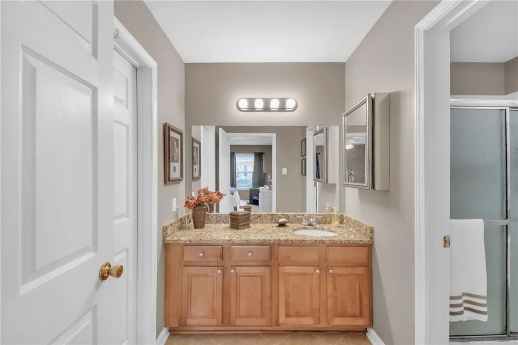 Full bathroom featuring vanity, a shower with door