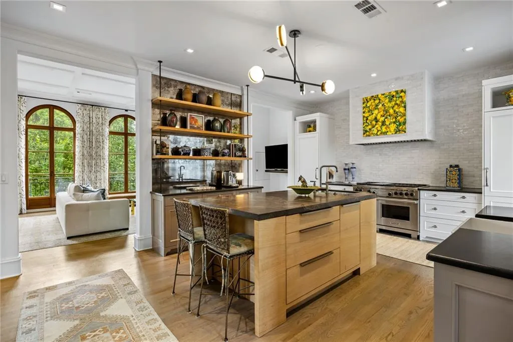 Central kitchen island with a dark countertop and light wood-finish cabinetry