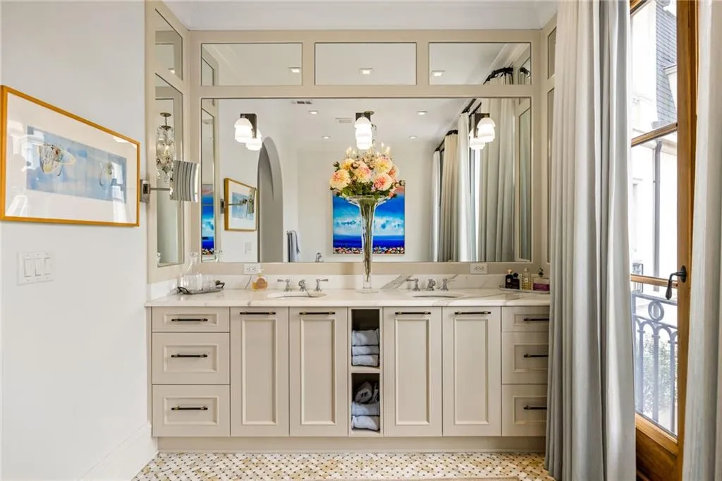 Dual vanity with neutral cabinetry, light-toned countertop, and mosaic tile flooring