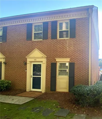 Brick facade with dark shutters and decorative cornice