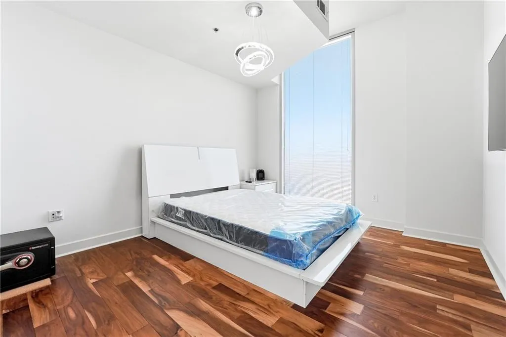 Bedroom with dark wood-style flooring and baseboards