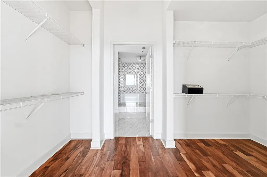 Walk in closet featuring dark wood finished floors