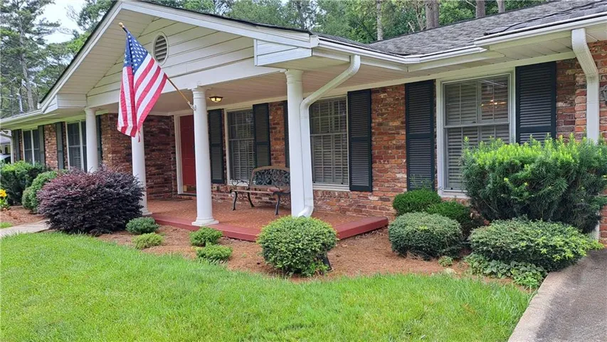 Brick exterior with white columns and contrasting black shutters