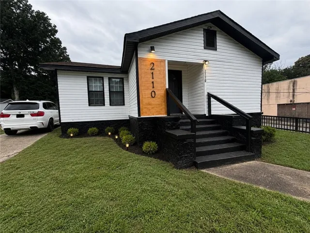 White siding exterior with black trim, black entry stairs, and a black front door