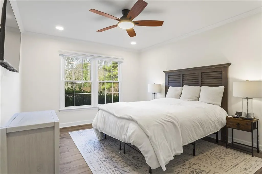 Room featuring wood-finish flooring, recessed lighting, and a ceiling fan with integrated light