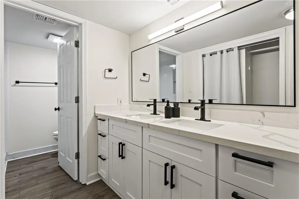Bathroom featuring a double vanity with white cabinetry, white countertop, and integrated sinks