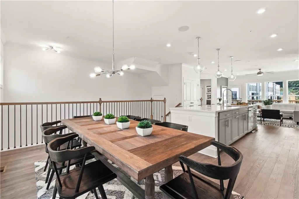 Dining area with light wood-style flooring, recessed lighting, ceiling fan, and a chandelier