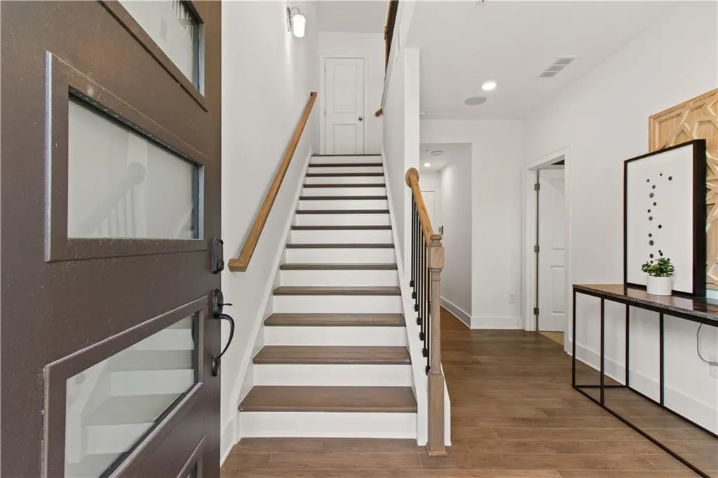Staircase featuring wood finished floors and recessed lighting