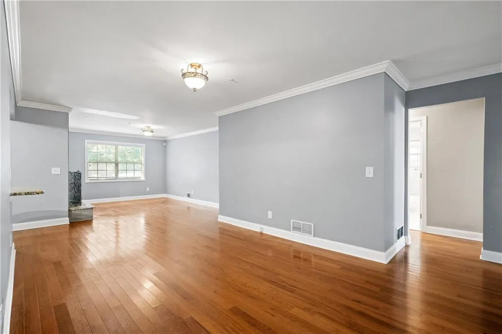 Spare room featuring ornamental molding and hardwood / wood-style flooring