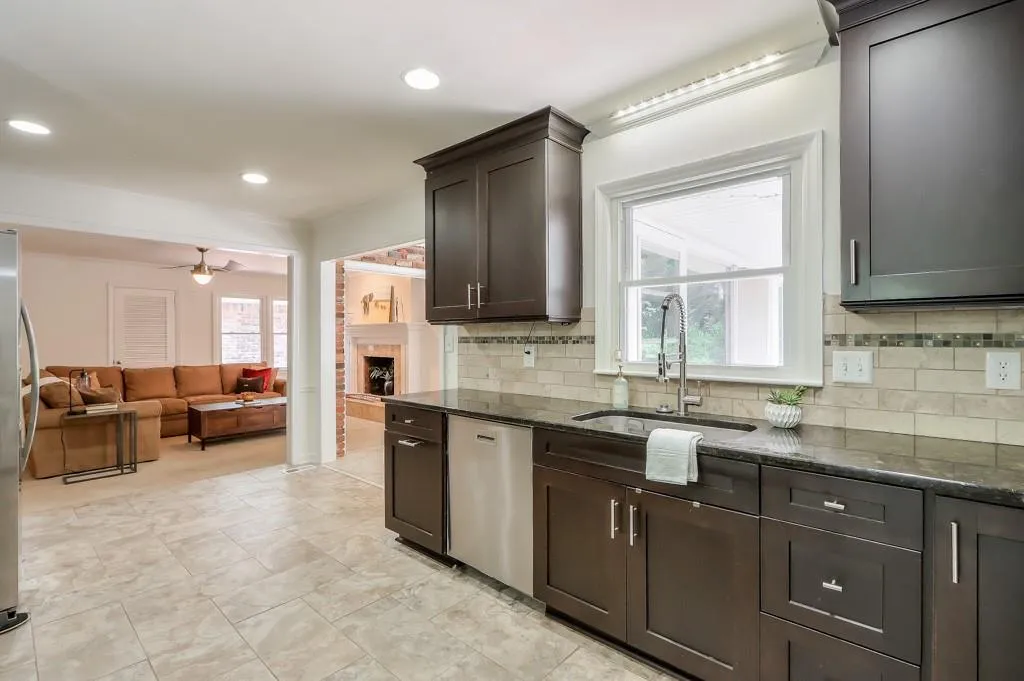 Kitchen with appliances with stainless steel finishes, sink, ceiling fan, and granite countertops