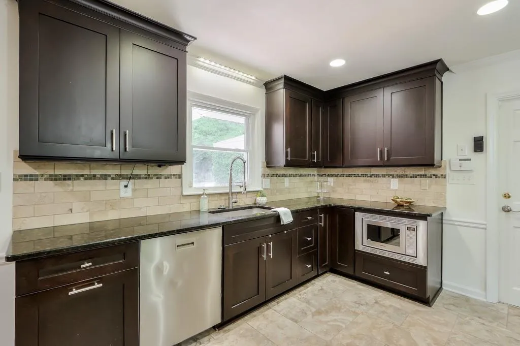 Kitchen featuring granite counters, stainless steel dishwasher, built in microwave, and sink