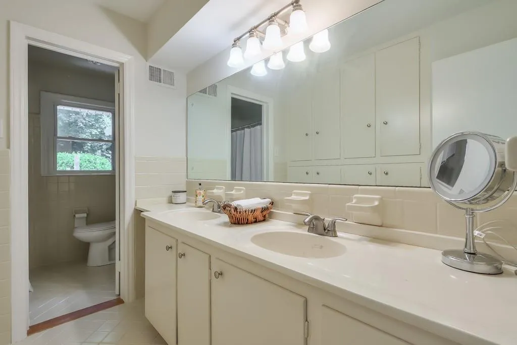 Bathroom with double vanity, tile walls, backsplash and tile floors