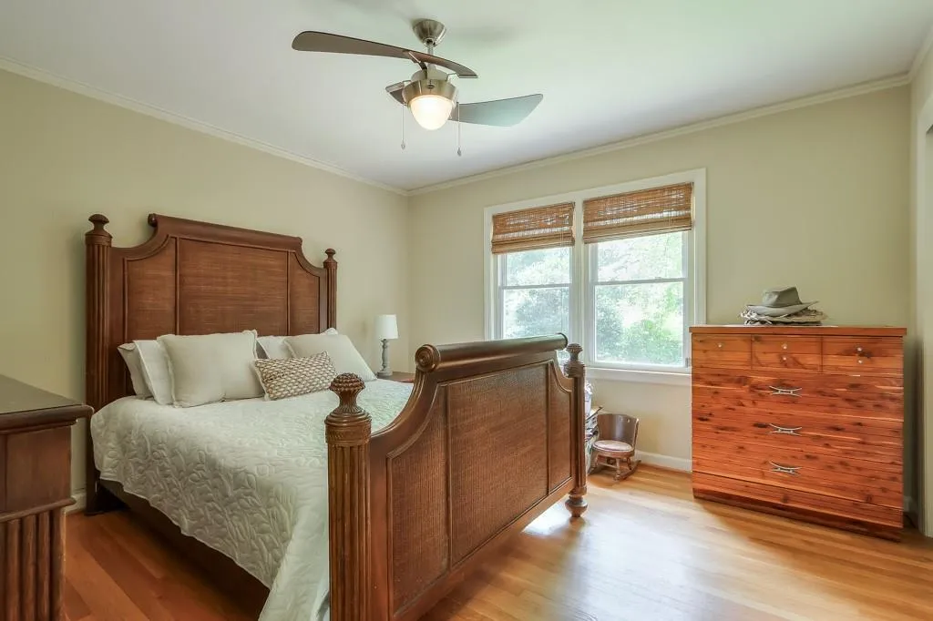 Bedroom with crown molding, ceiling fan, and hardwood / wood-style floors