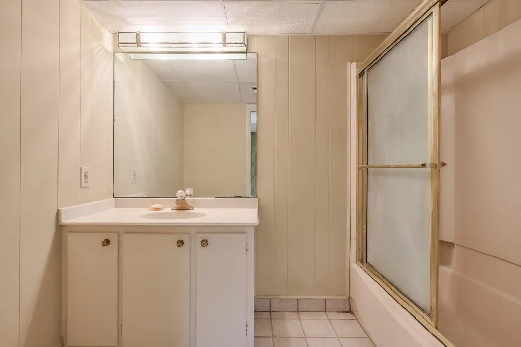 Bathroom featuring vanity, tile flooring and shower / bath combination with glass door