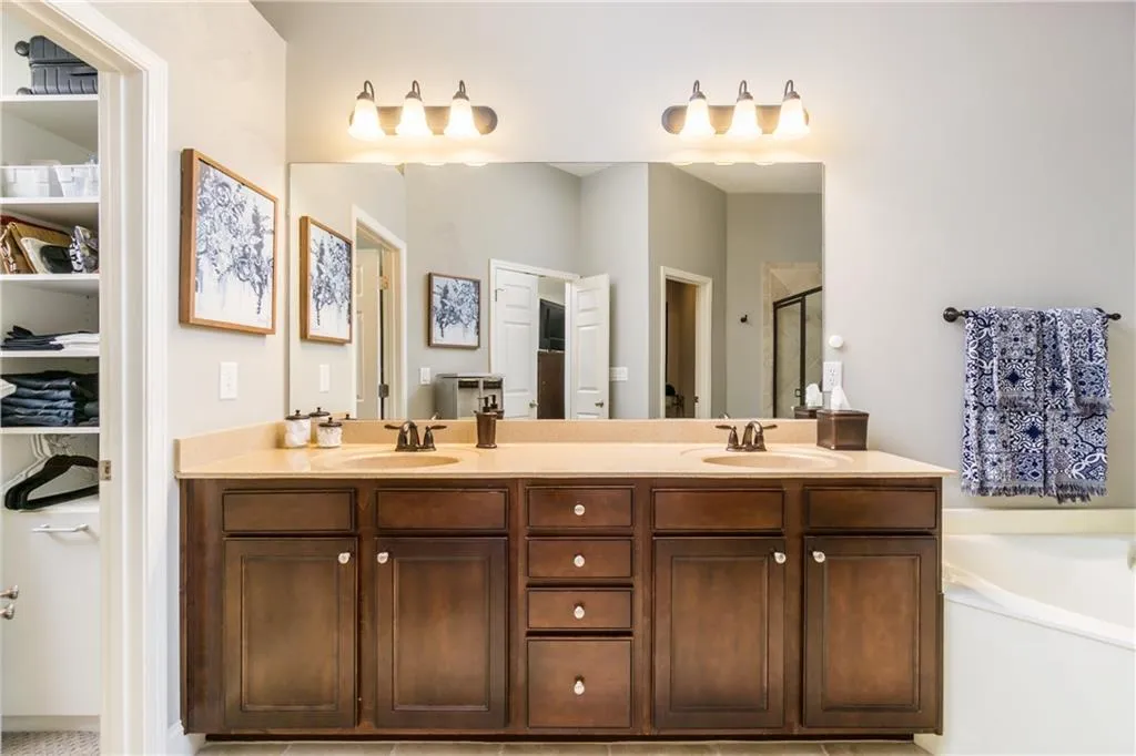 Bathroom with a stall shower, double vanity, and a bath