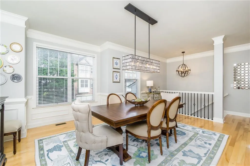 Dining area featuring ornamental molding, light wood-style flooring, and a chandelier