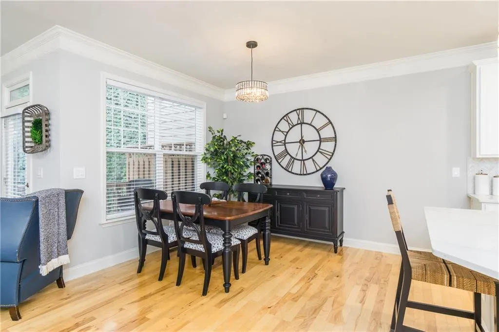 Dining room featuring crown molding, light wood-style floors, and a chandelier