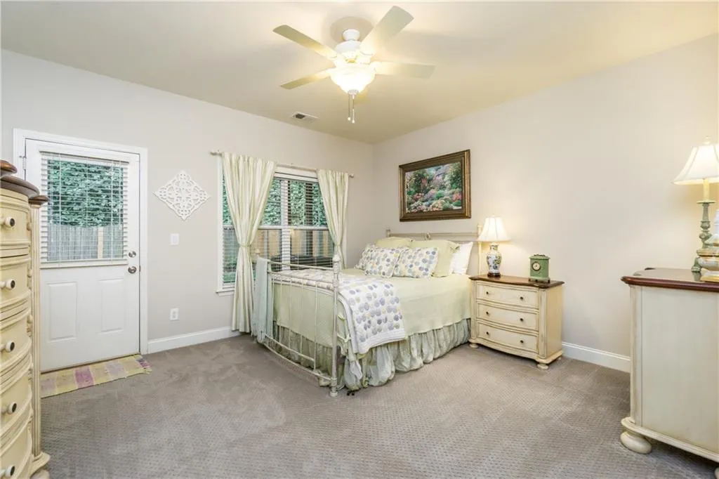 Carpeted bedroom featuring ceiling fan and baseboards