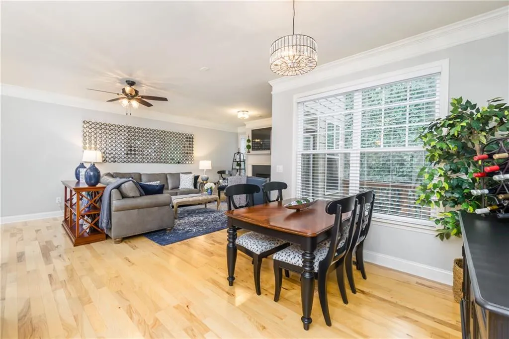 Dining space featuring crown molding, light wood finished floors, and ceiling fan