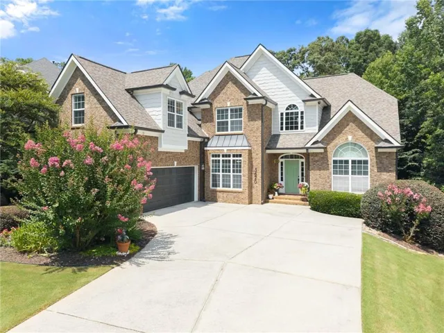 Brick exterior featuring white shingle accents and a multi-level roofline