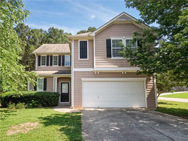 Two-story residence featuring light brown siding and black window shutters