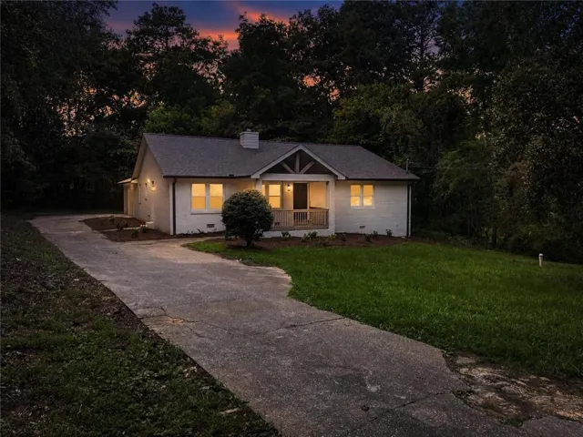 White exterior with dark roof and a covered porch