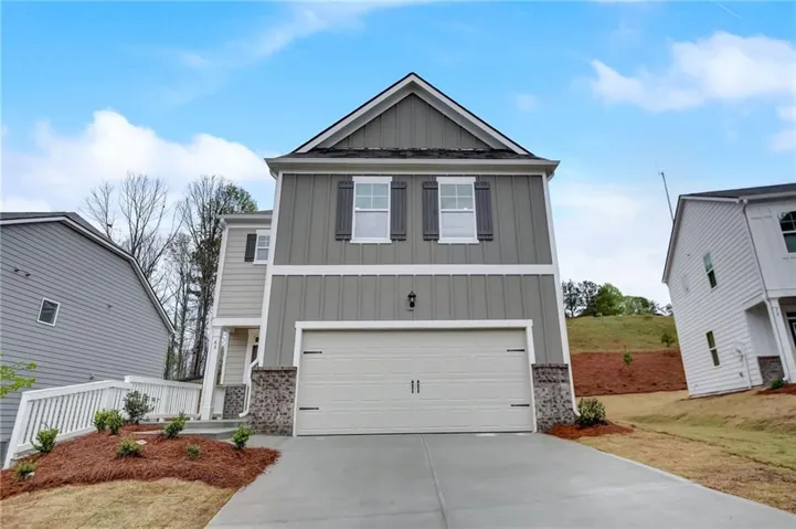 Two-story exterior with board and batten siding and stone accents