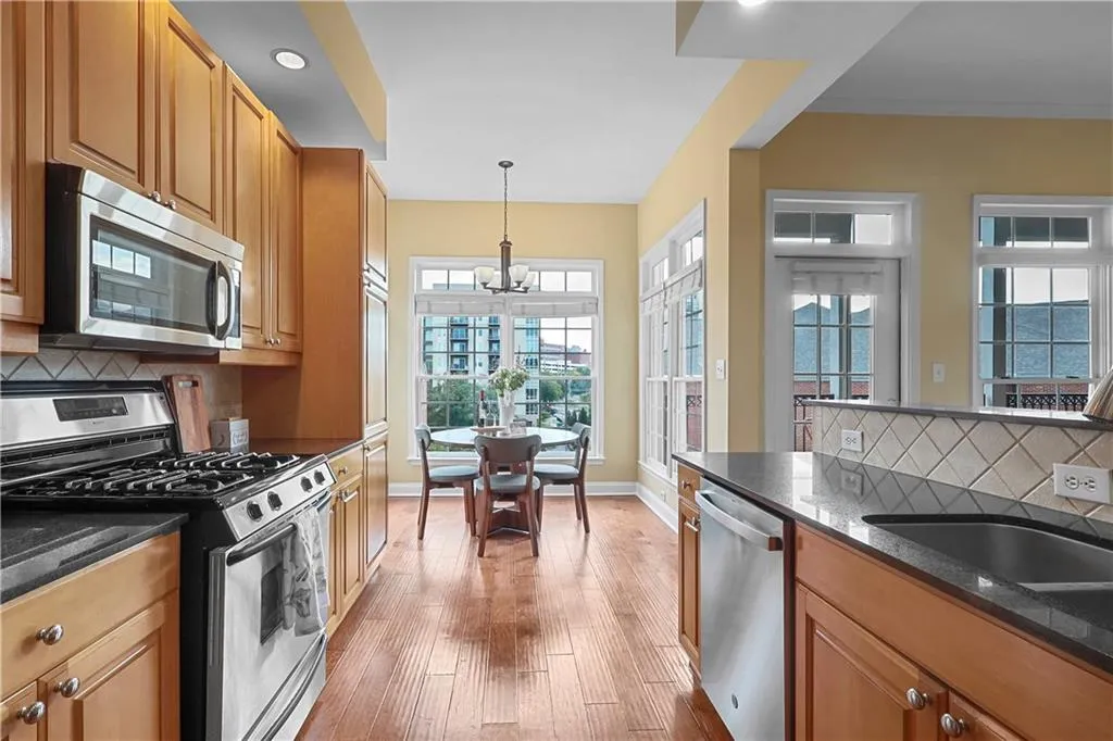 Kitchen with tasteful backsplash, appliances with stainless steel finishes, dark stone counters, and recessed lighting