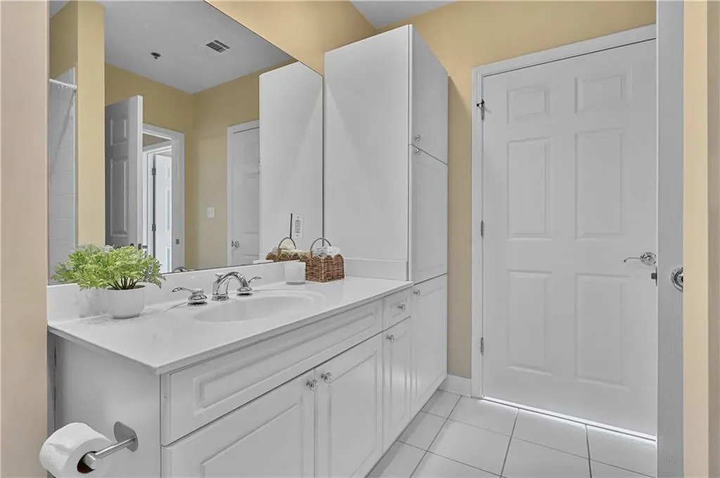 Full bath with light tile patterned flooring and vanity