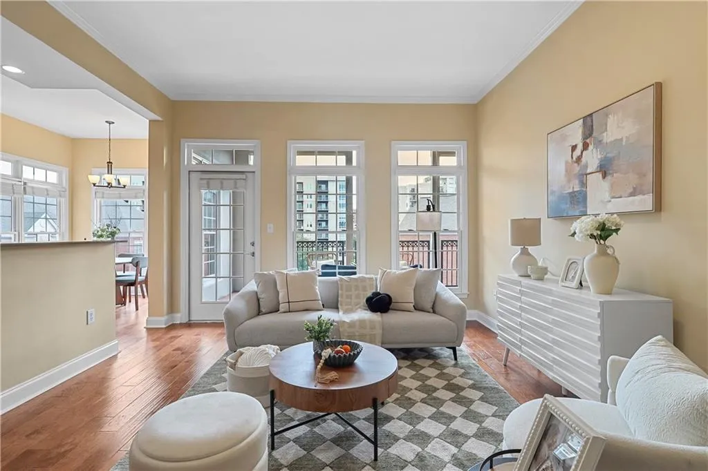 Living room with wood-type flooring, ornamental molding, and a chandelier