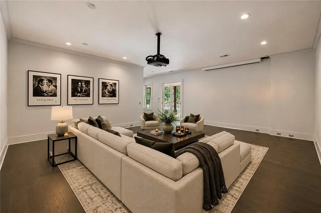 Entertainment space featuring dark wood-finish flooring, recessed lighting, crown molding, a built-in projector, and a retractable screen
