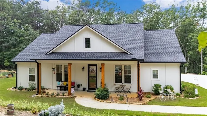 White board-and-batten exterior with a dark shingle roof