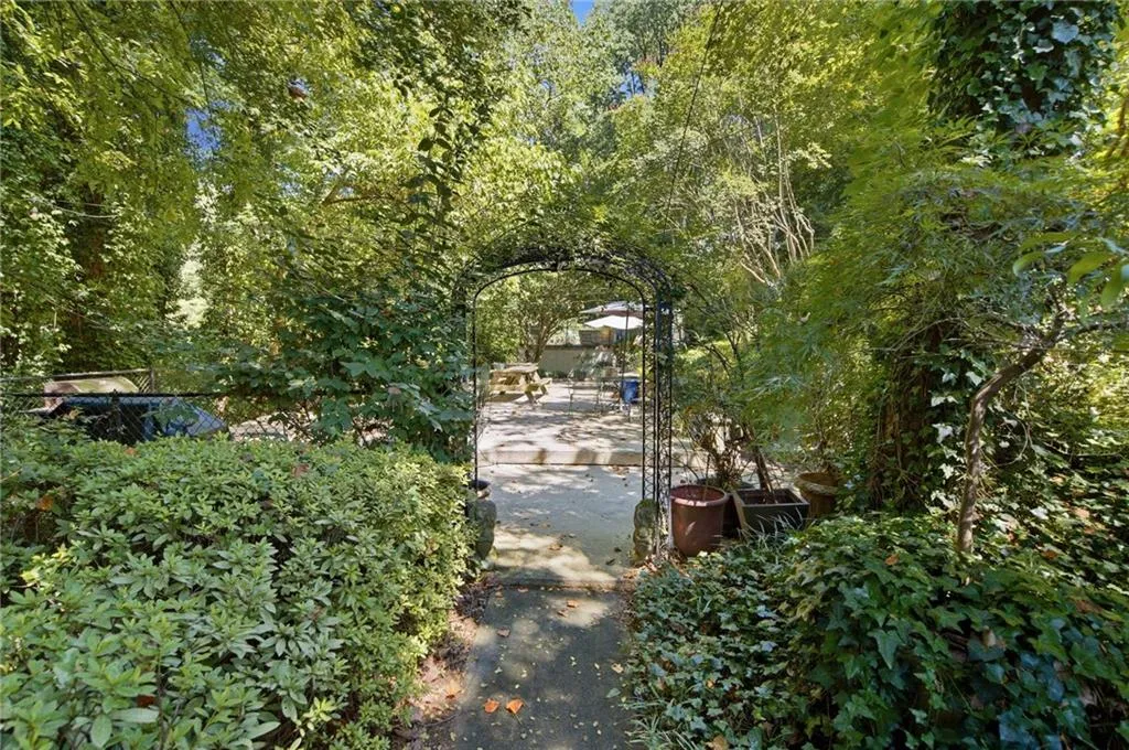 Garden archway leading to a paved patio area