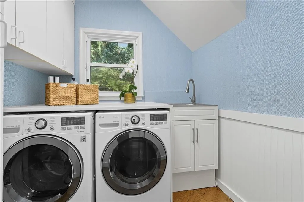 Large laundry room on main floor with wash sink and plenty of cabinetry