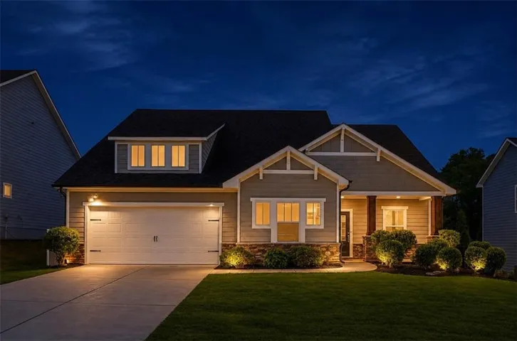 Craftsman-style exterior with stone accenting, prominent front porch, dormer window, attached garage, and concrete driveway