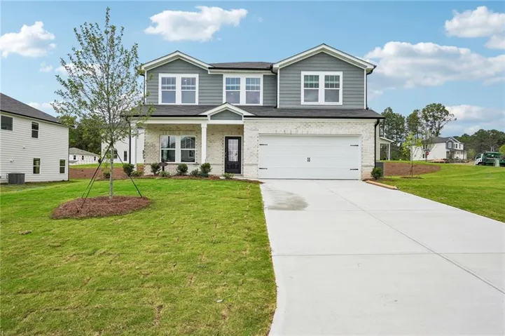 Two-story property featuring a white brick and gray siding exterior, a two-car garage, a covered front porch, and a concrete driveway