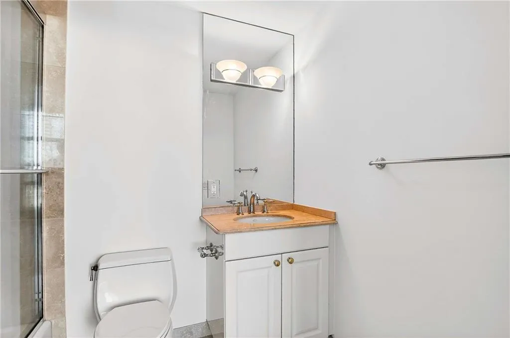 Bathroom featuring vanity and enclosed tub / shower combo