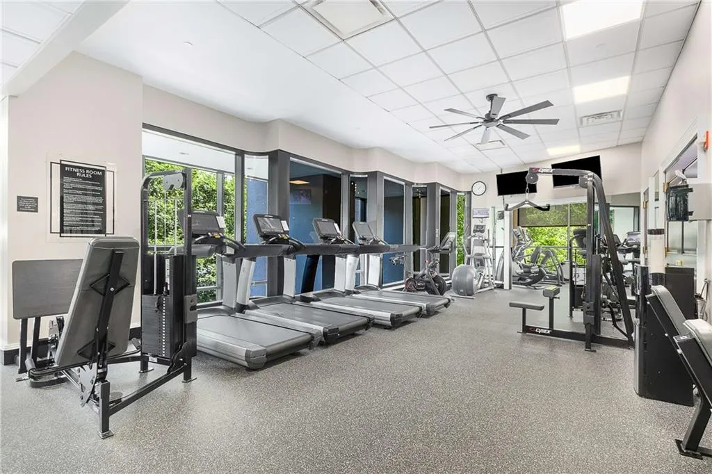 Exercise room with a paneled ceiling and ceiling fan