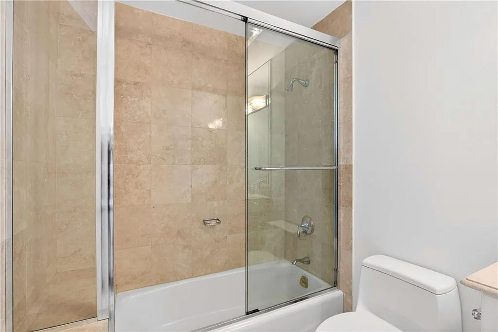 Full bathroom with enclosed tub / shower combo and vanity