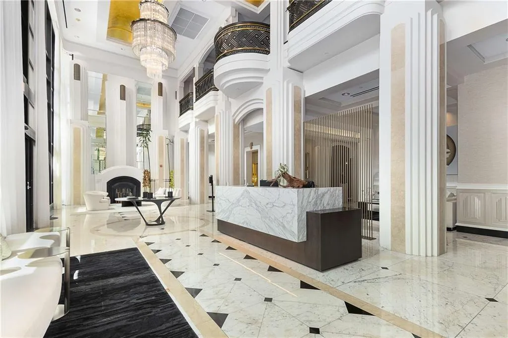 Reception with a high ceiling, a fireplace, decorative columns, and a chandelier