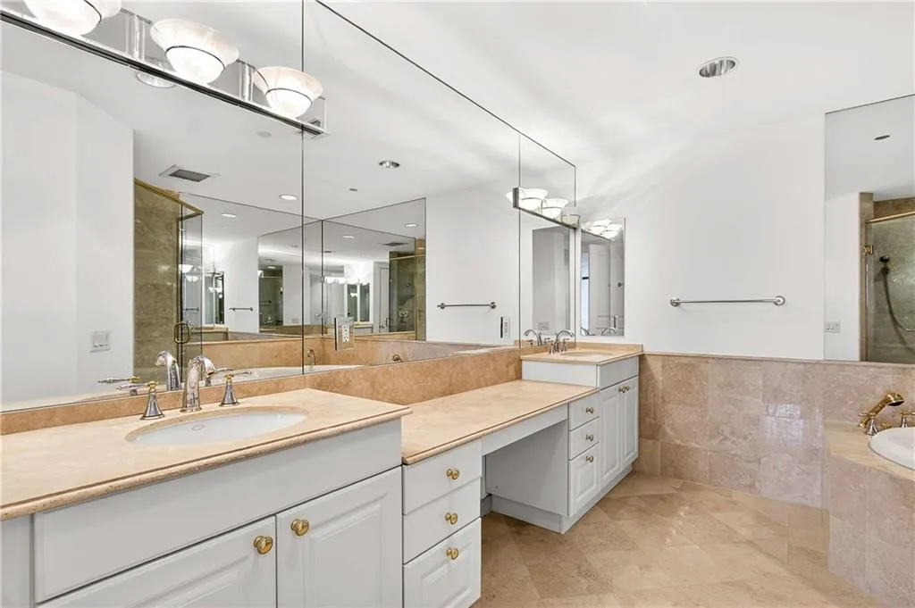 Full bath featuring a shower stall, double vanity, a garden tub, recessed lighting, and tile walls