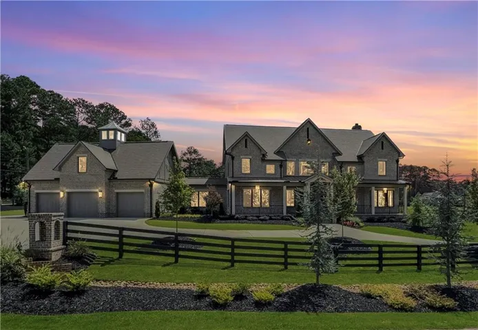 View of front facade featuring a fenced front yard, a garage, driveway, and a chimney