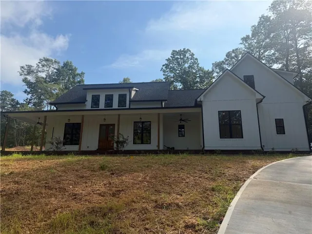 Modern farmhouse exterior with white vertical siding and black-framed windows