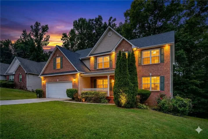 View of front of property featuring a porch, a front yard, driveway, and brick siding