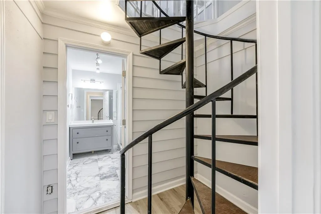 Stairs featuring light hardwood / wood-style floors and ornamental molding