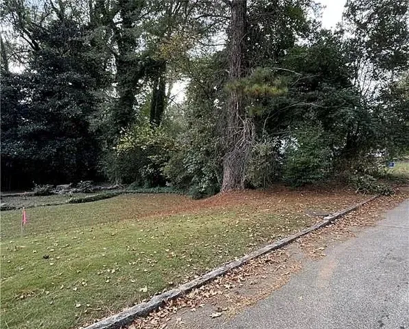 View of green lawn featuring view of scattered trees