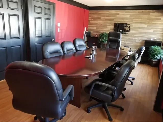 Spacious room featuring wood-finish flooring and a rich red accent wall
