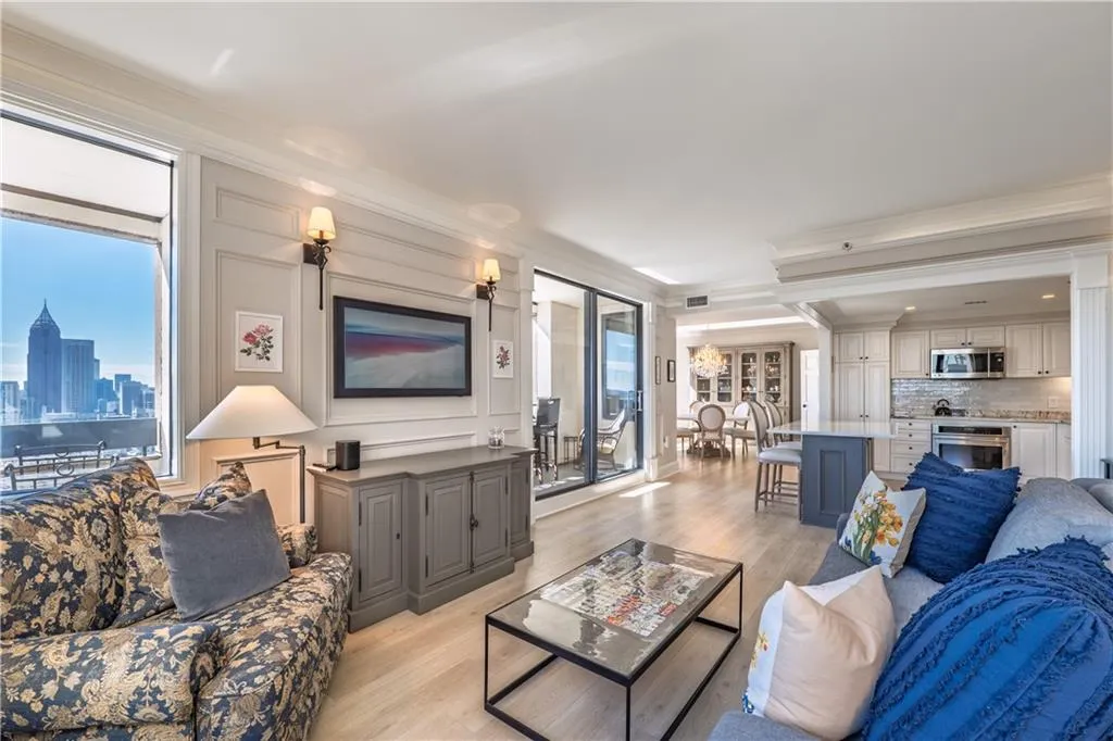 Living room featuring crown molding, light wood-style flooring, and a wealth of natural light
