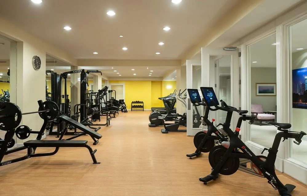 Exercise room with carpet floors and recessed lighting